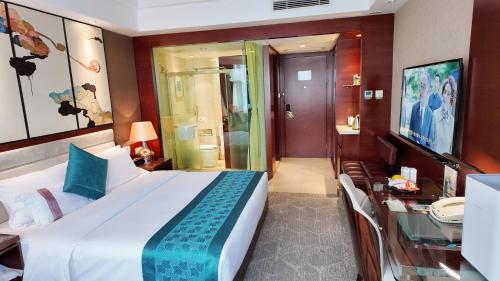 a bedroom with a large bed and a glass table at Kunming Haitian Hotel in Kunming