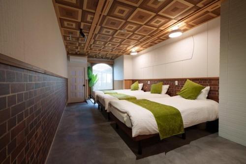 a room with four beds with green pillows at 岐阜城まで一番近い駅まで徒歩圏内無料駐車場有り in Gifu