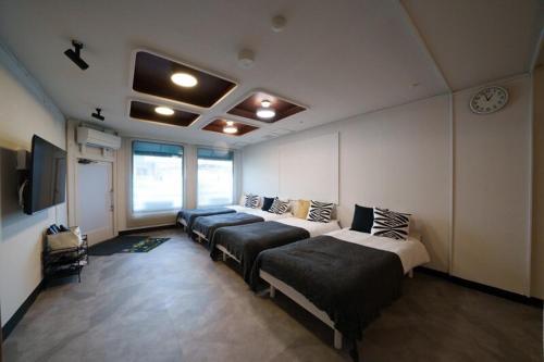a room with four beds and a clock on the wall at 岐阜城まで一番近い駅まで徒歩圏内無料駐車場有り in Gifu