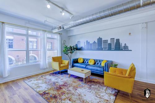 a living room with a blue couch and yellow chairs at The Stallion #208 - Walk to Attractions - Modern Luxe Loft in Memphis Downtown with free covered gated parking in Memphis