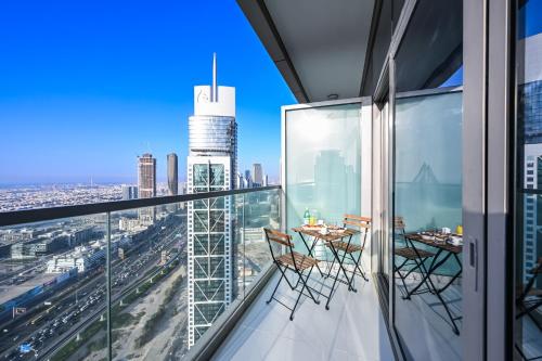 a balcony with a table and chairs on top of a building at New Luxury SeaView 2Bed - Spectacular Rooftop Infinity Pool, Bar & Burj Views! in Dubai