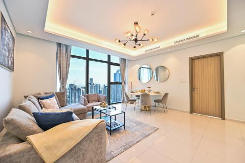 a living room with a couch and a table at New Luxury SeaView 2Bed - Spectacular Rooftop Infinity Pool, Bar & Burj Views! in Dubai