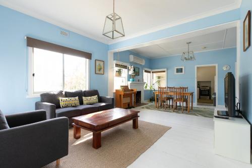 a living room with a couch and a table at Cosy, historic & affordable 2-bed apartment - 5kms from Castlemaine, 2kms from Calder in Barkers Creek