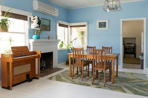 Un comedor con mesa y sillas y chimenea. en Cosy, historic & affordable 2-bed apartment - 5kms from Castlemaine, 2kms from Calder, en Barkers Creek