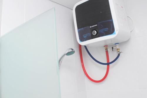 a red stethoscope hanging on a wall at Homey and Minimalist 2BR at Patraland Urbano Apartment By Travelio in Bekasi