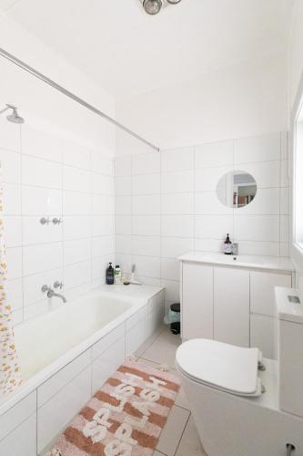 a white bathroom with a tub and a toilet at Cosy, historic & affordable 2-bed apartment - 5kms from Castlemaine, 2kms from Calder in Barkers Creek