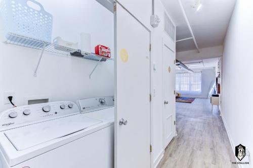 a white laundry room with a washer and dryer at The Stallion #209 - Walk to Museums, Luxe Loft with free gated & covered parking in Memphis
