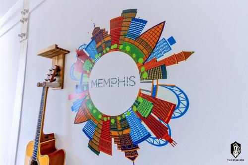 a collage of cities in a circle on a wall with a guitar at The Stallion #209 - Walk to Museums, Luxe Loft with free gated & covered parking in Memphis