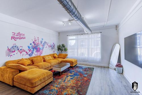 a living room with a couch and a tv at The Stallion #209 - Walk to Museums, Luxe Loft with free gated & covered parking in Memphis