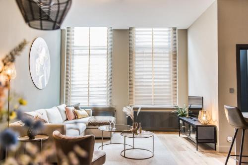 a living room with a couch and tables at Haya Historic - Rosé in The Hague