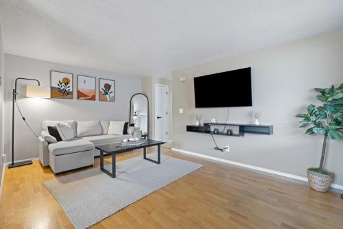 a living room with a couch and a tv on a wall at Casamor - Richland Home in Richland