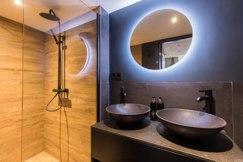 a bathroom with two vessel sinks and a mirror at Haya Historic - Rosé in The Hague