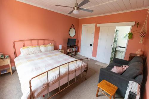 a bedroom with a bed and a couch at Cosy, historic and affordable entire cottage - 3 bedroom, 2 bathroom - 5kms from Castlemaine, 2kms from Calder in Barkers Creek