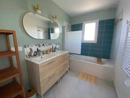 une salle de bain avec une baignoire, un lavabo et un miroir dans l'établissement Villa climatisée avec Wi-Fi et parking à Balaruc-les-Bains - FR-1-503-182, à Balaruc-les-Bains