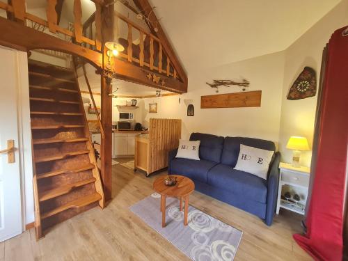 un salon avec un canapé bleu et une table dans l'établissement Chalet Nina: Havre de paix en bord de rivière avec climatisation - FR-1-589-794, à Anould