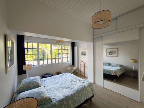 une chambre avec deux lits et deux fenêtres dans l'établissement Villa rénovée 4 ch. à 50m du Bassin avec terrasse et jardin, WIFI, parking - FR-1-736-54, à Lège-Cap-Ferret