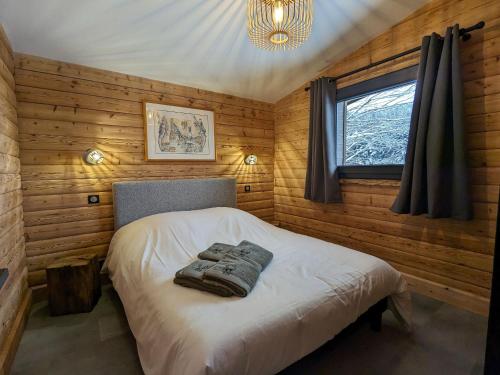 a bedroom with a bed in a wooden wall at Chalet rénové avec sauna, proche Gérardmer - FR-1-589-796 in Sapois