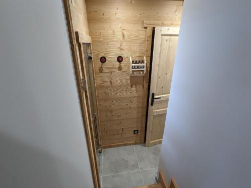 an empty room with a wooden wall and a door at Chalet rénové avec sauna, proche Gérardmer - FR-1-589-796 in Sapois