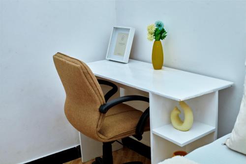 un escritorio blanco con una silla y un ordenador portátil. en Tarona peaceful homes - 1br apartment in Mtwara, en Mtwara