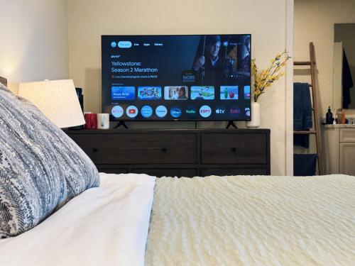 a bedroom with a bed and a large screen television at Hollywood Hills Haven-Guest House in Los Angeles