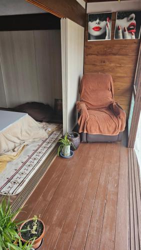 a small room with a bed and a wooden floor at 民宿SAZANAMi in Hagi