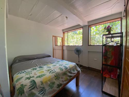 een kleine slaapkamer met een bed en twee ramen bij Casa Mariposa Ometepe Suite in Santa Cruz