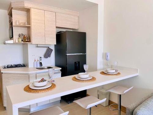 a kitchen with a counter with two tables and a refrigerator at Morros EOS Manzanillo piso 3 in Cartagena de Indias