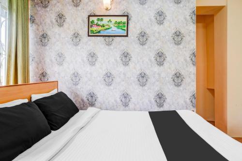 a bedroom with a bed and a wall at Super Hotel O Shillong Formerly Balaji Guest House in Shillong