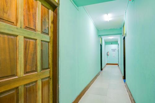 a hallway with a wooden door and a tile floor at Super Hotel O Shillong Formerly Balaji Guest House in Shillong