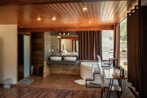 a bathroom with two sinks and a bath tub at Hotel California Urubamba in Urubamba