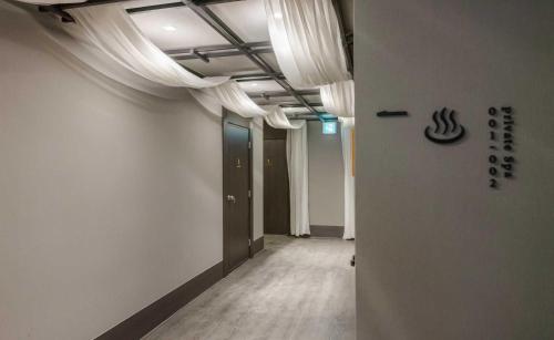 an empty hallway with white walls and curtains in a room at Aank Ryokan Hotel Jeonju in Jeonju
