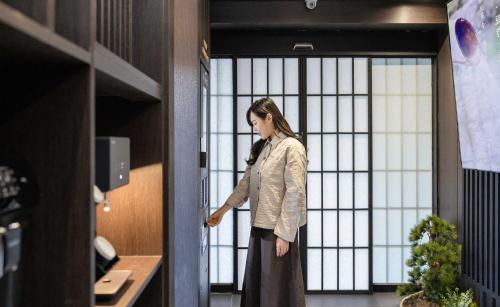 a woman standing in front of a large window at Aank Ryokan Hotel Jeonju in Jeonju
