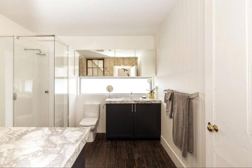 a bathroom with a sink and a toilet and a shower at Warders Quarters Amazing Location Freo in Fremantle