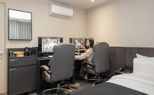 a woman playing a video game in a hotel room at Aank Ryokan Hotel Jeonju in Jeonju