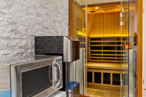 a kitchen with a microwave and a refrigerator at Ocean Sands Beach Boutique Inn-1 Acre Private Beach-St Augustine Historic-2 Miles-Shuttle with Downtown Tour-HEATED Salt Water Pool until 420AM-Popcorn-Cookies-New 4k USD Black Beds- 69 Item Breakfast-Eggs-Bacon-Starbucks- Free Laundry- #904-799-SAND in Saint Augustine