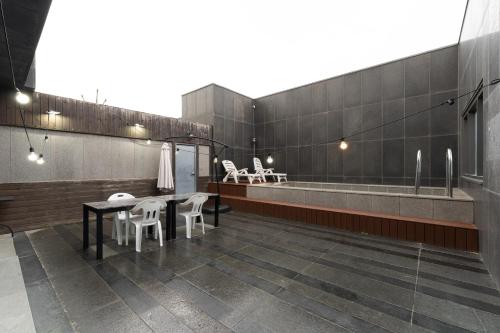 仁川市Browndot Hotel Incheon Songdo的配有桌椅和浴缸的客房