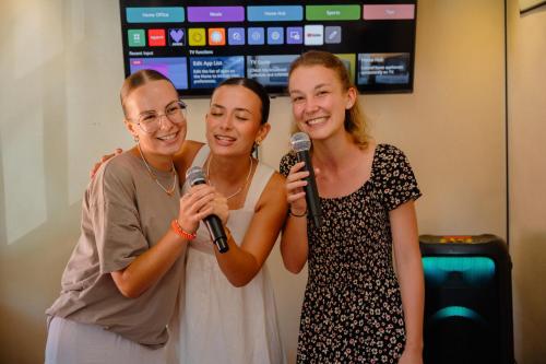 two women standing with microphones in a room at Chamee Oasis Villa in Ranna
