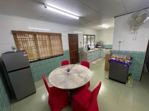 a kitchen with a table and red chairs in a room at Desa Tebrau 31 ikea AEON 15 paxs in Johor Bahru