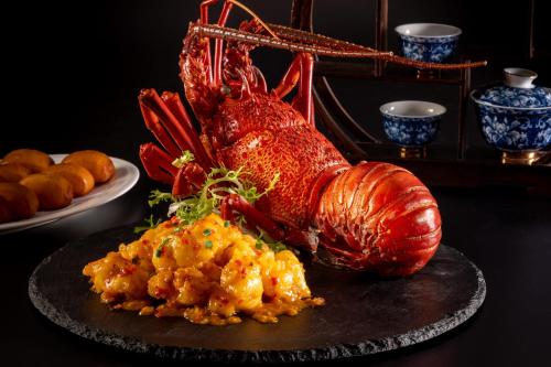 a lobster on a plate next to a plate of food at Carlton Hotel Bangkok Sukhumvit in Bangkok