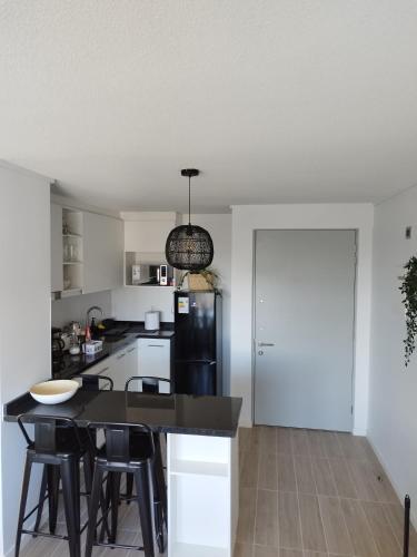 a kitchen with a black counter and a black refrigerator at Departamento encanto del sur isla teja in Valdivia