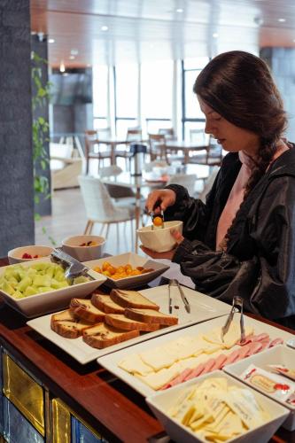 Una mujer sentada en un buffet de comida. en Hotel California Urubamba, en Urubamba