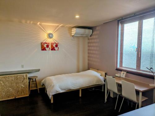 una stanza con un letto, una scrivania e una finestra di My Room a Takahata