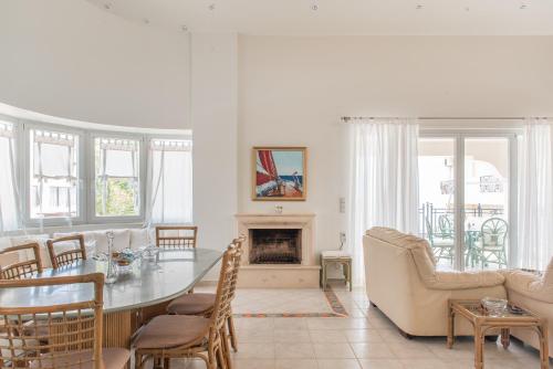 una sala de estar con una mesa y una chimenea en The Beach House, en Hersonissos