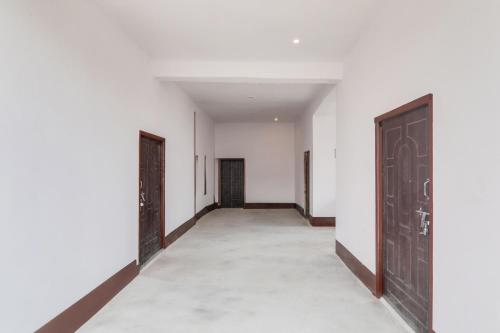 an empty corridor with white walls and doors at SPOT ON Hotel chitransh inn in Lucknow