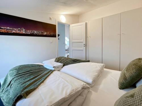 ein Schlafzimmer mit einem Bett und einem Gemälde an der Wand in der Unterkunft The Green 20 of Stavanger BnB in Stavanger