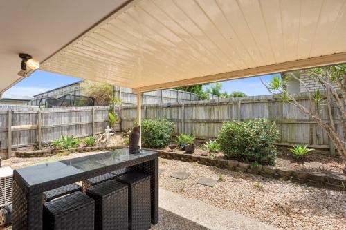 a patio with a wooden fence and a large umbrella at Royal Romanesque holiday house in Dakabin in Dakabin