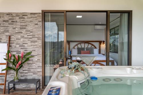a bath tub in a room with a bedroom at Villa Alma de Campo Monteverde in Monteverde Costa Rica