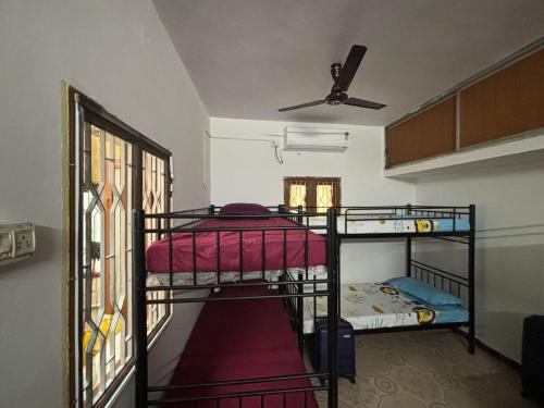 a room with two bunk beds and a ceiling at Hostel Madras in Chennai