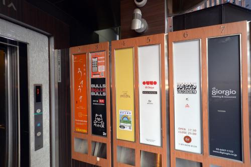 a row of signs on the side of a building at illi Gran Azabujuban in Tokyo