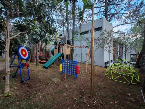 a playground in front of a building with trees at Serenzzo Hotel & Cuisine in Tapalpa